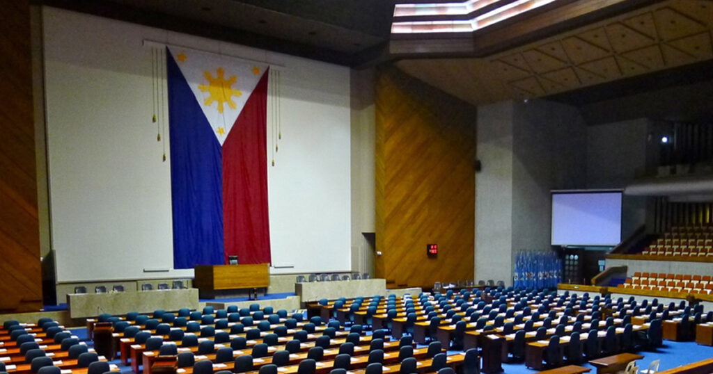 Empty session hall of the House of Representatives with a large Philippine flag